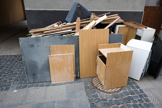 Bulky waste collection. Display of old furniture and electronic waste on the street.
