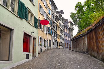 Fototapeta premium Cobblestone street and old buildings in the old town of Zurich, Switzerland