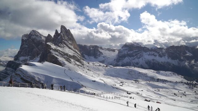 Time Laps of Winter hikers cross the Seceda alpine trail near Villn&ouml;&szlig;, South Tyrol (S&uuml;dtirol), Italy, beneath dramatic Dolomite peaks, ideal for travel campaigns.