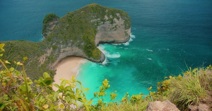 Famous T Rex shaped cliff overlooks the white sand of Kelingking Beach in Nusa Penida Bali