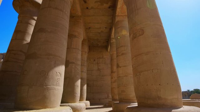Ruins of Ramesseum mortuary temple with giant Ramesses II Osiride statues. Upward view of massive carved columns and hieroglyphic lintels at Ramesseum temple Luxor Egypt.