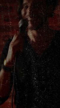 Vertical video: Male singer shifting grip bringing mic near, leaning, singing for music crowd