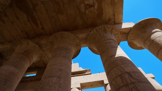 Ruins of Ramesseum mortuary temple with giant Ramesses II Osiride statues. Upward view of massive carved columns and hieroglyphic lintels at Ramesseum temple Luxor Egypt.