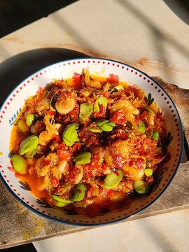 Spicy shrimp cooked with petai beans and chili sambal, served on a plate. Traditional Indonesian seafood dish, rich in flavor and perfect for Asian cuisine and food concepts.