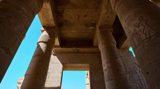Ruins of Ramesseum mortuary temple with giant Ramesses II Osiride statues. Upward view of massive carved columns and hieroglyphic lintels at Ramesseum temple Luxor Egypt.