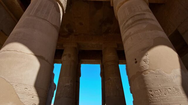 Ruins of Ramesseum mortuary temple with giant Ramesses II Osiride statues. Upward view of massive carved columns and hieroglyphic lintels at Ramesseum temple Luxor Egypt.
