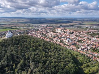 Fototapeta premium Aerial view of the historic center of Mikulov and the pilgrimage site of Svatý Kopeček. Sunny day with partly cloudy sky. Czech Republic, South Moravia.