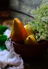 Conference pears. Still life featuring bowl with sweet pears,  autumn atmospheric mood, flowers and fruits. Harvesting, village, countryside © ElenaEmiliya