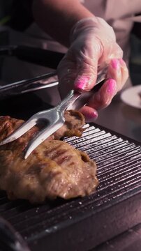Cooking a steak. A professional chef prepares delicious meat on a hot grill.