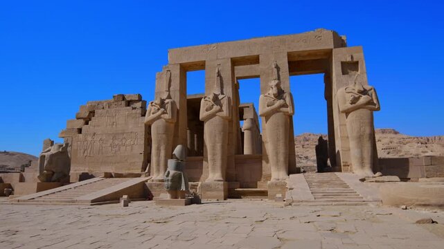 Ruins of Ramesseum mortuary temple with giant Ramesses II Osiride statues. It is located in the Theban necropolis in Upper Egypt, across the River Nile from the modern city of Luxor. Egypt.