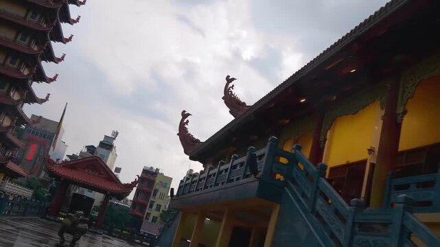Traditional Asian style bended tiled roofs with exotic serpent like chofas on the edges cover temple buildings from the rain. Viet Nam Quoc Tu Pagoda (Vietnamese National Pagoda) Ho Chi Minh City