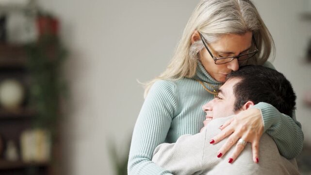 Loving mother tenderly hugging her adult son with a physical condition. Heartwarming family moment of care, support, and unbreakable bond