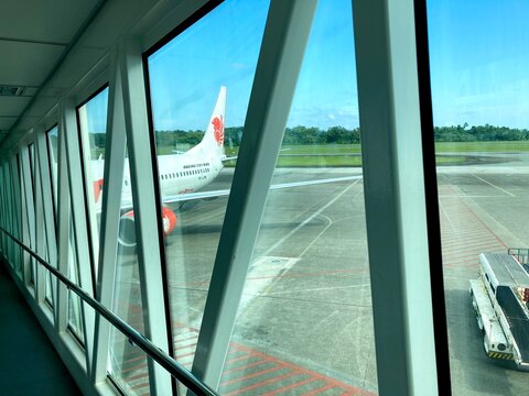 view of a passenger airplane through an airport jet bridge window
