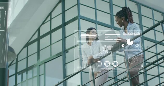 Two colleagues on mezzanine opening laptop activating overlays cycling graphs for business analysis