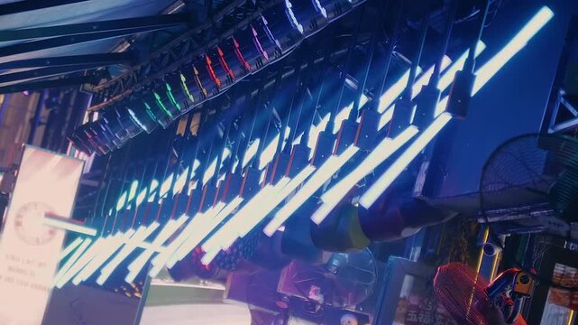 Dozens of luminous glowing neon pipe lights placed parallel and perpendicular to each other on the night street of Saigon, Vietnam