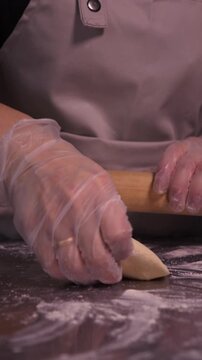 Kneading the pie dough. A woman rolls out the dough in the kitchen.