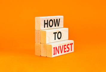 Naklejka premium How to invest words symbol. Concept words How to invest on beautiful wooden blocks. Beautiful orange background. Business and how to invest concept. Copy space.