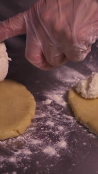 A girl cooks pies with cottage cheese . Vertical video about homemade pastries, cooking and confectionery