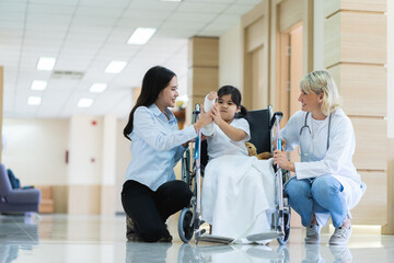 Obraz premium A woman in a white lab coat is helping a child in a wheelchair