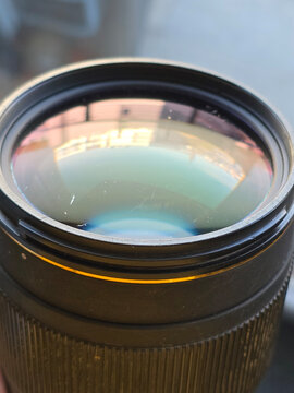 Close up of surface scratches and dust on the front glass element of a Sigma 70-200mm f2.8 II EX APO DG Macro HSM lens, Poland, Europe