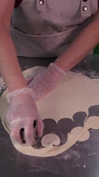 A woman cooks dumplings with meat filling. Vertical video.