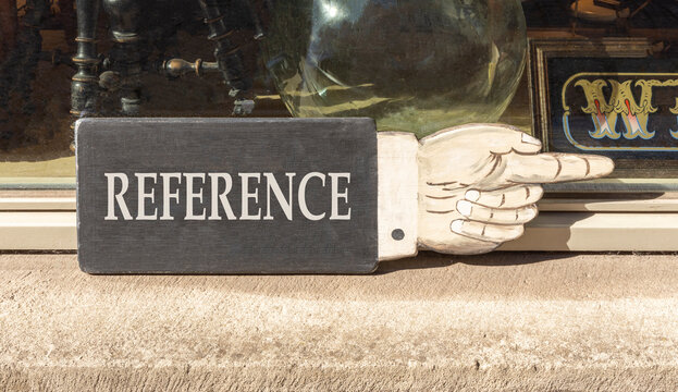 References or reference symbol. Concept word Reference on beautiful black wooden sign as a hand. Beautiful store front background. Business references or reference concept. Copy space.