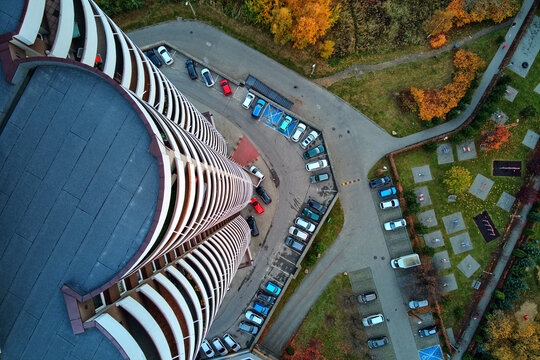 Looking down from a drone at the curved balconies of a Kukurydze building and a colorful autumn playground, Katowice, Slask, Poland, Europe.