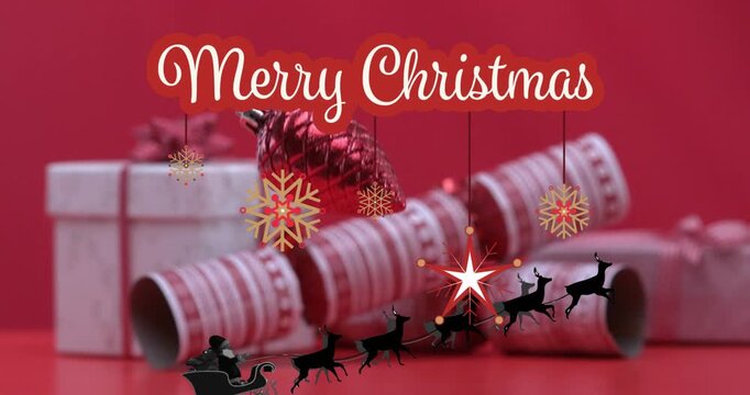 Animation of merry christmas text banner over party popper and gifts against red background