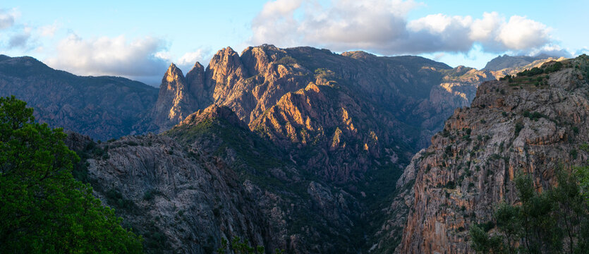 Spelunca Gorge Corsica 11k panorama of Monte Cinto massif at sunset. Scenic view of majestic green peaks and rugged mountains near Evisa along D81 road in France. Highland scenery at golden hour