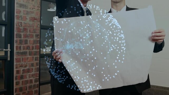 Two professionals holding blank sheet in business office, showing floating holographic data globe