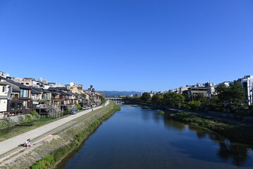 Fototapeta premium 京都・鴨川に広がる青空と街並みの風景 Scenic view of the Kamo River and cityscape under a clear blue sky in Kyoto