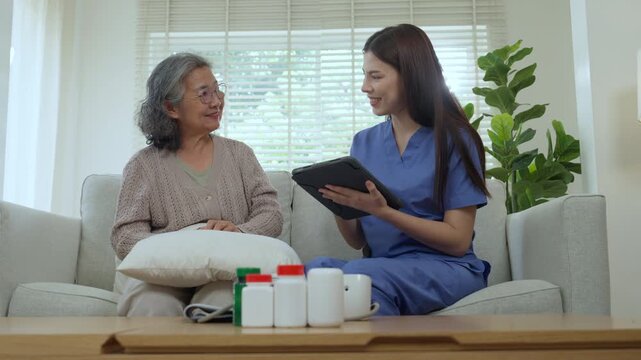 Caregiver and elderly share care at home as nurse uses tablet for healthcare consultation and support with medication, building trust and dignity in bright living room that feels calm and hopeful