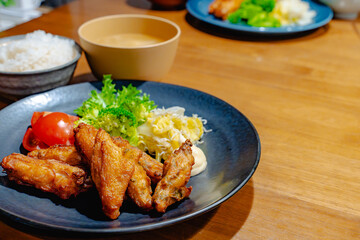 Fototapeta premium 唐揚げとサラダの定食 賑わう家庭の食卓