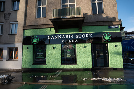 Vienna, Austria- Feb 21, 2026: A cannabis store with a bright green exterior showcases its services, inviting customers in an urban setting with promotional signage.