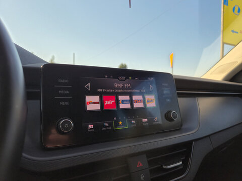 Warsaw, Poland - February 15, 2026: Interior view of modern car displaying RMF FM radio station on touchscreen with various sound options and bright daylight.