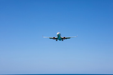 Fototapeta premium Aircraft landing at Phuket International Airport over Mai Khao Beach, Thailand.