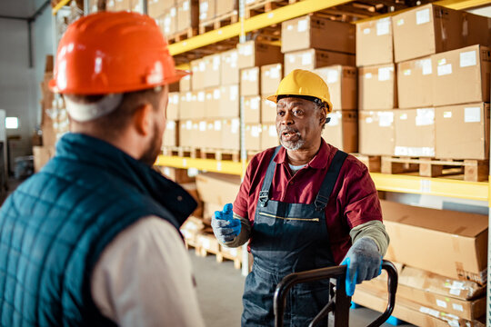 Warehouse employees discussing workflow in distribution center