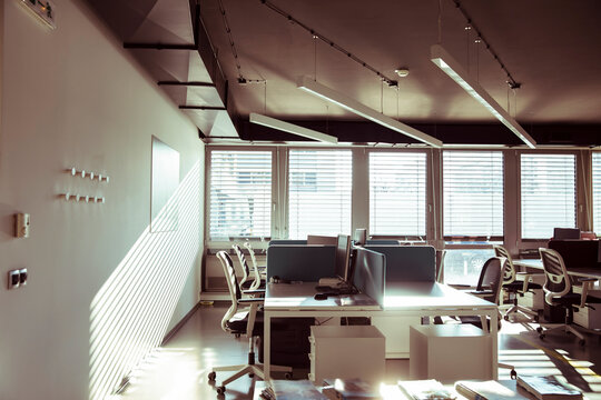 Business office interior with desks and computers in sunlight