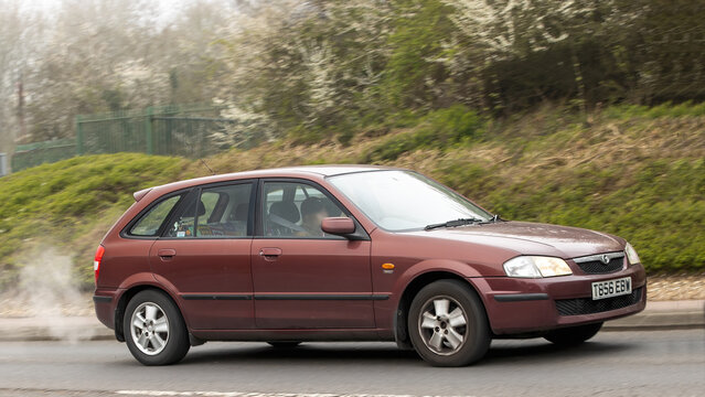 Milton Keynes,Bucks,UK - Mar 22nd 2026:  1999 red Mazda 323 car driving on a British road