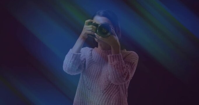 Female photographer in studio raising DSLR to eye and pressing shutter then reviewing composition