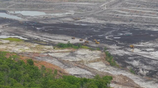 Aerial view of vast coal mines and dump truck activity loading and transporting coal