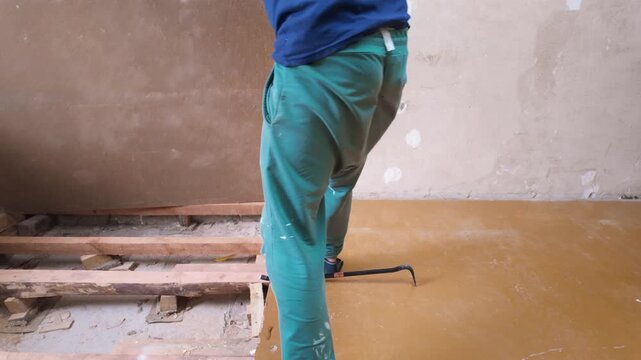White Contractor Removing Subfloor Panels And Lifting Boards In Renovation Room, Active Demo Using Crowbar And Gloves With Visible Debris And Exposed Joists, Gritty HandsOn Renovation