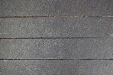 Fototapeta premium Texture of gray natural stone flooring with neat cement borders for building exterior areas.