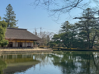 Obraz premium Traditional Japanese thatched house reflected on pond at 有備館, Iwadeyama