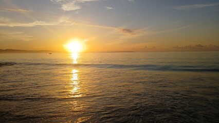 Fototapeta premium Panoramic view of golden sunrise over the calm ocean horizon.