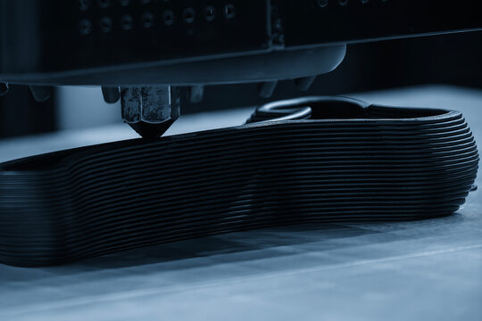 Close-up of the intricate multi-layer structure of a workpiece being fabricated on an advanced 3D printing machine.