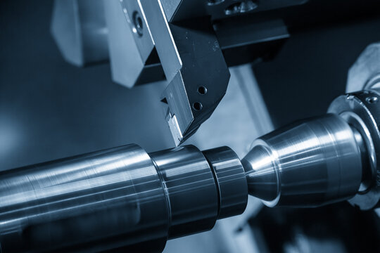 High-precision CNC lathe machine performing a finish cut on a metal shaft part for a smooth surface finish.
