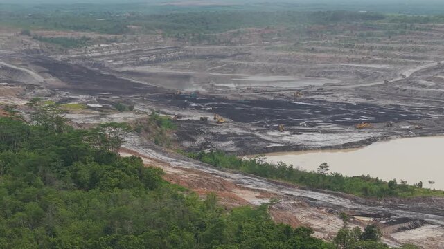 Aerial view of vast coal mines and dump truck activity loading and transporting coal