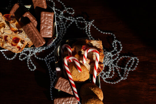Sunlit plate of candy canes homemade ginger biscuits and tim tams on table at Christmas