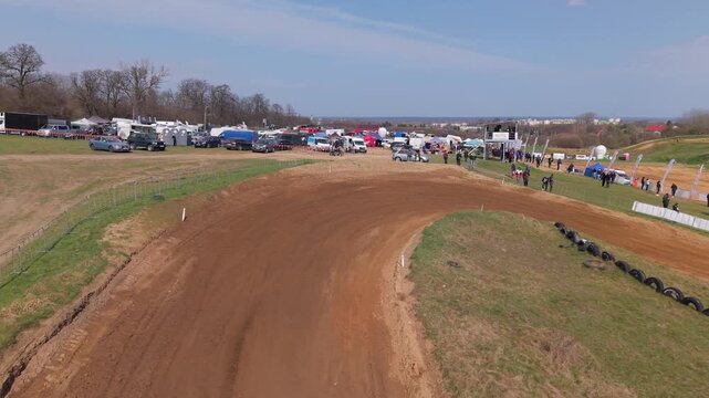 Aerial drone footage of motocross cross country race, dirt bikes speeding on rugged track, riders competing in off-road extreme motorsport event, dynamic action and dust clouds